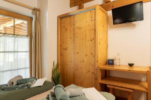 a room with two beds and a television on a wall at La Culla Stube in Padola