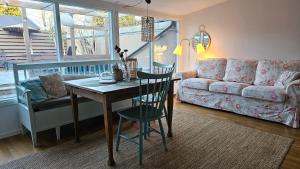 ein Wohnzimmer mit einem Tisch und einem Sofa in der Unterkunft Real holiday feeling with sauna in Beddinge Strand
