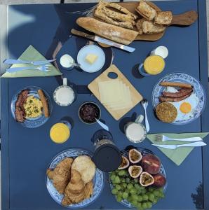 a blue table topped with plates of breakfast foods at Gîte la Cabridello in Barbentane +16 photos