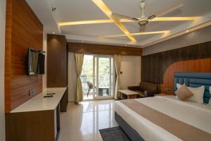 a bedroom with a bed and a tv and a couch at Trayee International in Digha