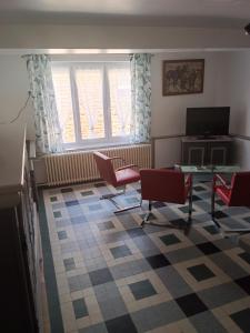 a living room with chairs and a table and a window at Gîte du piémont in Mouzon