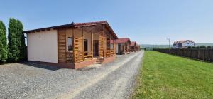 a row of small wooden buildings on a gravel road at Casute de Vacanta - Complex Ben in Ocna Sibiului