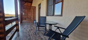 a room with two chairs and a table on a balcony at Casute de Vacanta - Complex Ben in Ocna Sibiului