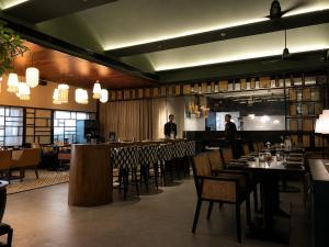 two men standing in a restaurant with tables and chairs at Hotel Star City in Chennai +57 photos