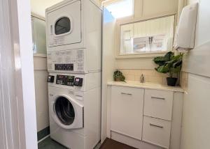 a white laundry room with a washer and dryer at The Beaconsfield Hotel in Fremantle