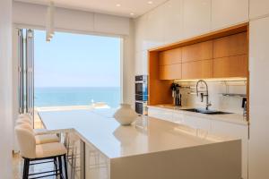 a kitchen with a large white counter and a large window at Olymp Luxury Residence in Kissonerga