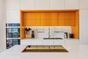 a kitchen with white counters and wooden cabinets at Olymp Luxury Residence in Kissonerga