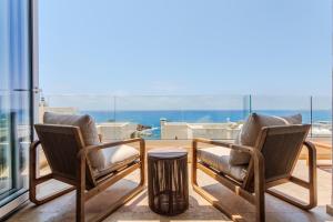 a balcony with two chairs and a trash can at Olymp Luxury Residence in Kissonerga
