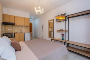 a bedroom with a large bed and a kitchen at Μυρτιές-Mirties in Siviri +39 photos