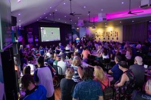 a crowd of people sitting in a room with a screen at The Beaconsfield Hotel in Fremantle