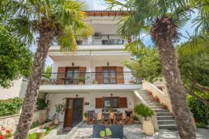 a house with palm trees in front of it at Μυρτιές-Mirties in Siviri