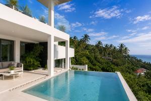 a villa with a swimming pool and the ocean at INDIGO VILLA Samui in Koh Samui