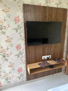 a flat screen tv on a wall with floral wallpaper at KK Hotel in Jaipur