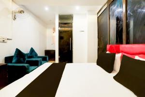 a bedroom with a bed and two blue chairs at Hotel O Kashish Residency in New Delhi +21 photos