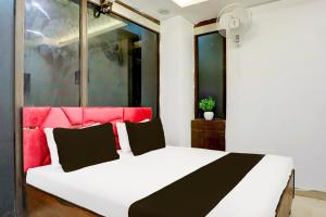 a bedroom with a white bed with a red headboard at Hotel O Kashish Residency in New Delhi