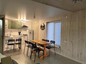 a kitchen with a wooden table and chairs at Wald Haus in Pulʼmo
