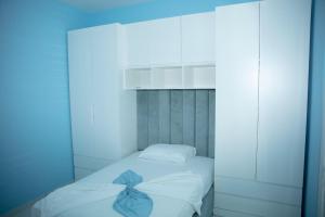 a white bed with a blue bow on it at Miri House in Domje