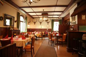 a restaurant with tables and chairs and a chandelier at Landgasthof Voltmer in Ramlingen