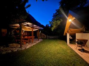 a backyard with a table and a grill at night at Edi Cottage in Bovec +26 photos