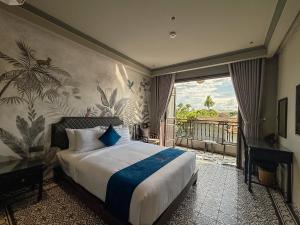 a hotel room with a bed and a balcony at KunKin Boutique Garden Hue in Thôn Dương Xuân Hạ