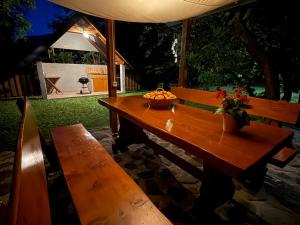 a wooden picnic table with a basket of fruit on it at Edi Cottage in Bovec