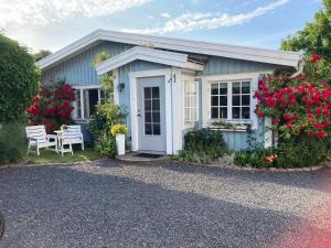 a small blue house with a table and flowers at LillaStugan in Jönköping