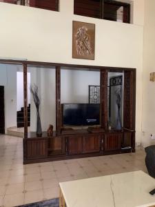 a living room with a television on a wooden entertainment center at MJ Marina in Mtwapa