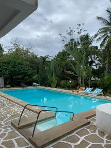 a large blue swimming pool with chairs and trees at MJ Marina in Mtwapa