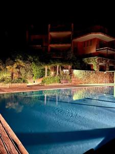 a swimming pool in front of a building at night at Le Pergole Aloha - Menaggio by LoveComo in Menaggio