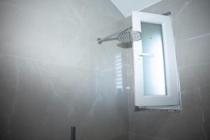 a bathroom with a shower with a mirror and a sink at Miri House in Domje +38 photos