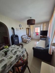 a living room with a table and a couch at Ország Apartmanház in Zalakaros