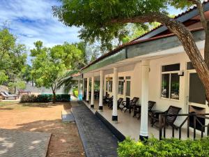 a porch of a house with chairs and trees at The Rock Yala in Yala
