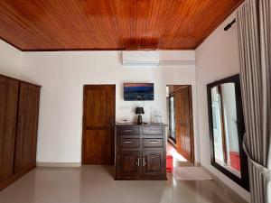 a room with a wooden ceiling and a dresser at Oli Villa in Belihuloya