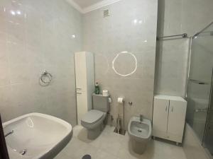 a white bathroom with a toilet and a sink at Casa Boa Nova Valadares in Valadares