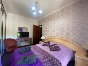 a bedroom with a purple bed and a tv at Casa Boa Nova Valadares in Valadares