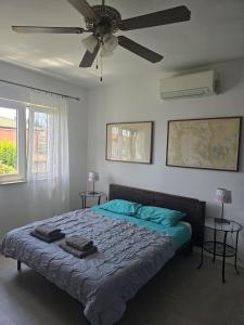 a bedroom with a bed with a ceiling fan at MILAN A4, 50 m from the beach in Novigrad Istria