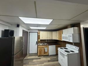 a kitchen with white appliances and wooden cabinets at Anchorage Fireoved Home Theater Experience in Anchorage +11 photos