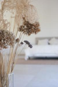 a vase with some dried flowers in it at Villa Hartebos in Kaprijke
