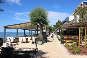 a woman walking down a sidewalk near the beach at MILAN A4, 50 m from the beach in Novigrad Istria