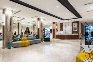 a lobby of a store with couches and a tv at Al Qasr Corniche in Jazan