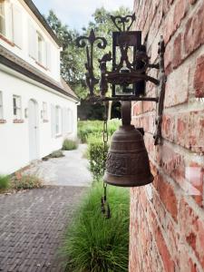 an old bell hanging on a brick wall at Villa Hartebos in Kaprijke +9 photos