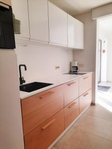 a kitchen with white cabinets and a sink at Villa Hartebos in Kaprijke