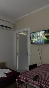 a bedroom with a bed and a flat screen tv on the wall at Duki's Apartments in Orikum
