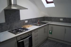 a small kitchen with a stove and a sink at Kirks Korner Motel in Scunthorpe