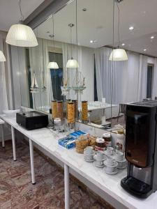 a table with cups and dishes on it in a room at Hotel BENGASI Marina Centro in Rimini +15 photos