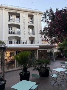 a hotel with tables and chairs in front of it at Hotel BENGASI Marina Centro in Rimini