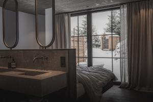 a bathroom with a sink and a large window at Mountain Hideway Birgkar in Mühlbach am Hochkönig +72 photos