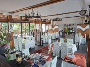 a dining room with white tables and chairs at Casa cu Stuf Olimp in Olimp