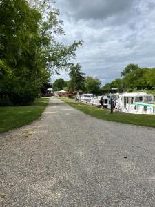 a gravel road with boats parked on the grass at Les cabane in Fleury-sur-Loire