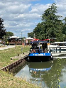 a blue boat is docked in a canal at Les cabane in Fleury-sur-Loire